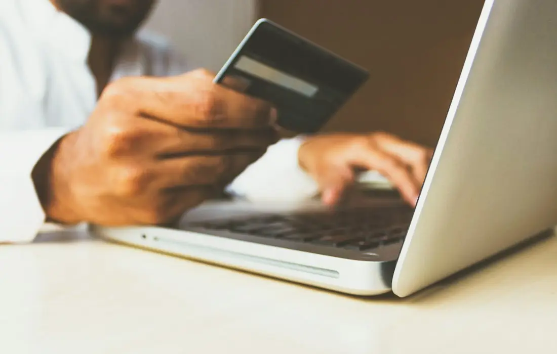Shopper paying online with a card on a laptop