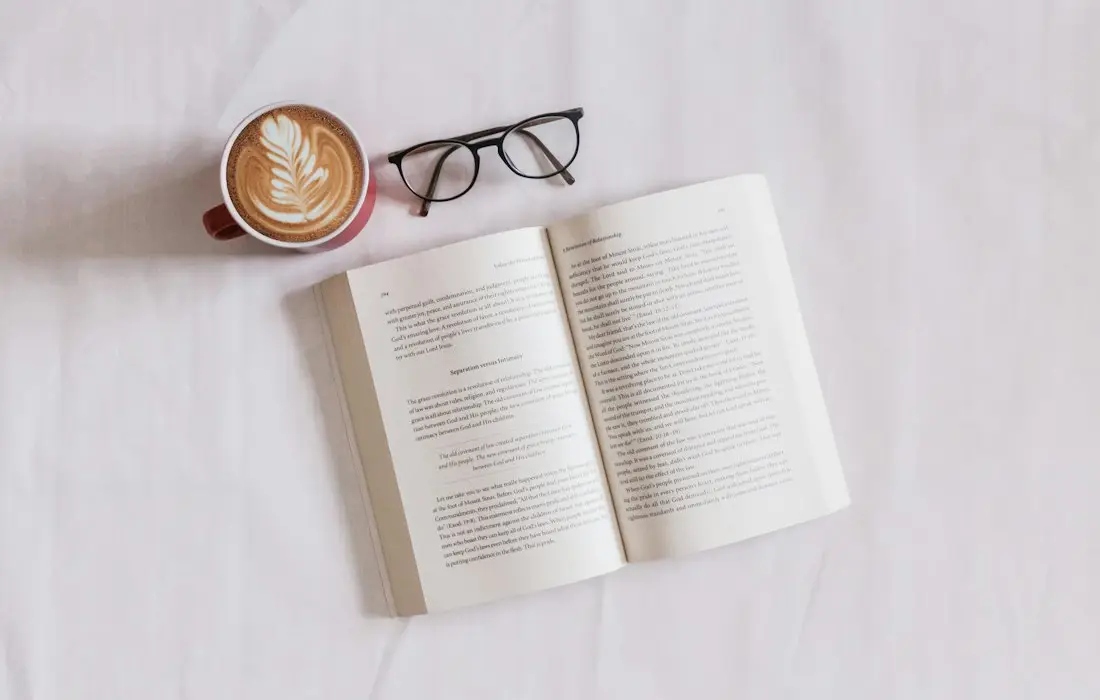 Open printed book with a cup of coffee